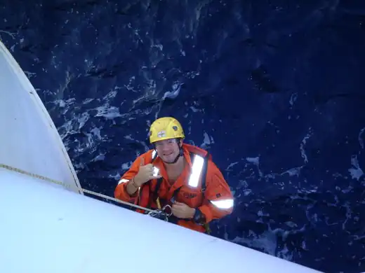 Ryan Hawkins on ropes offshore, above the open sea